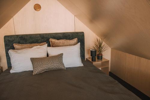 a bedroom with a large bed with white pillows at PullanHouse Līksma - small and cosy lakeside holiday house in Alūksne