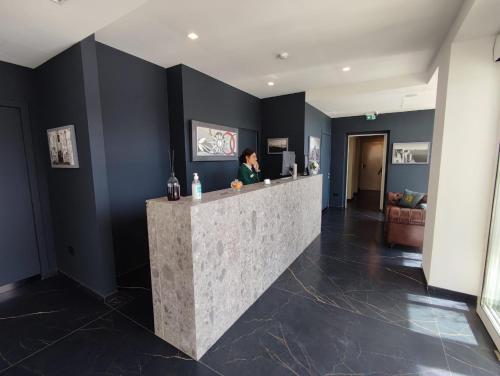 a woman standing at a counter in a lobby at Hotel XBusiness in Nola