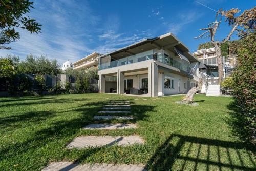 une grande maison blanche avec une cour en herbe dans l'établissement Blue Dream Luxury Rooms, à PalaiónTsiflíkion