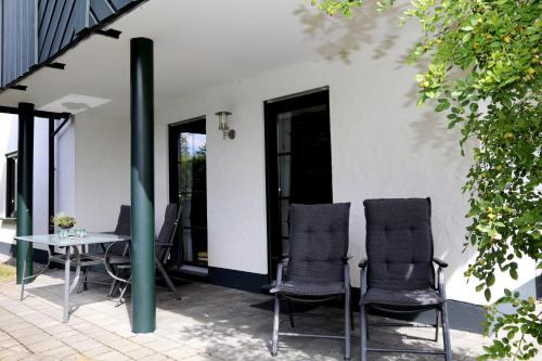 two chairs and a table on a patio at Ferienwohnung Sonnenhang-Hartmann in Olsberg
