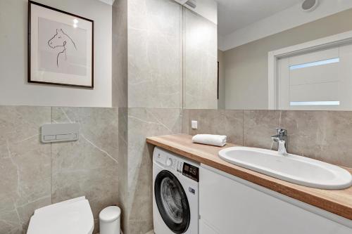 a bathroom with a washing machine and a sink at Flatbook - City Center Apartments Bastion Wałowa in Gdańsk