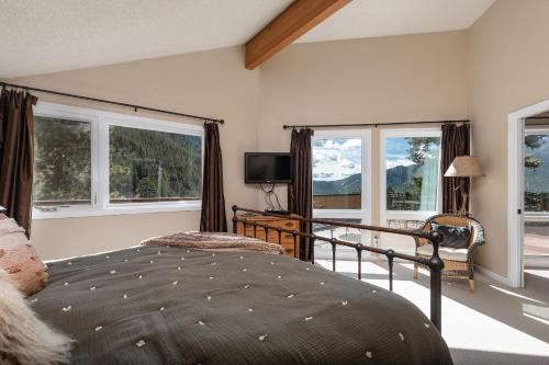 - une chambre avec un lit, des fenêtres et une télévision dans l'établissement Cedar Upper Condominium 3 Bedroom condo, à Estes Park