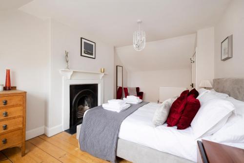 1 dormitorio con 1 cama blanca grande con almohadas rojas en 2 bed Haywood Cottage with garden, en Stenton