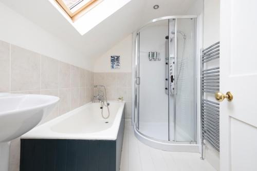 y baño con bañera, lavamanos y ducha. en 2 bed Haywood Cottage with garden en Stenton
