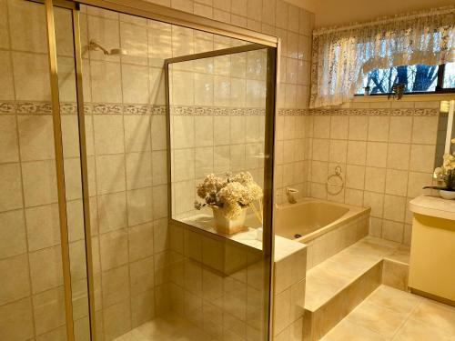 a bathroom with a shower and a sink and a tub at Luxe Ranch in Swan Hill