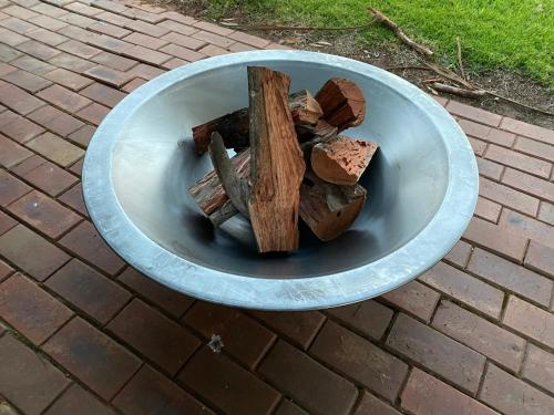 a bowl filled with chopped wood on a brick ground at Luxe Ranch in Swan Hill