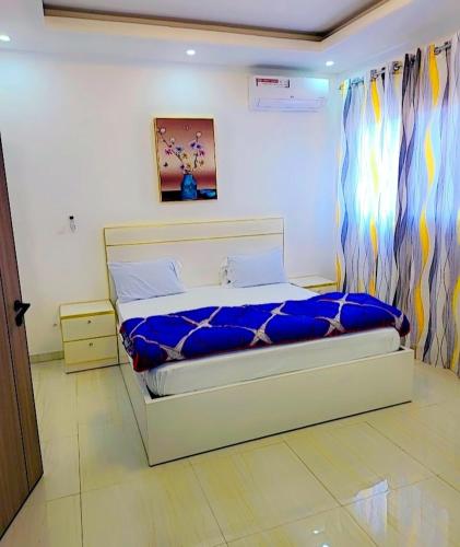 a bedroom with a bed with a blue blanket at Beau séjour VIP in Dakar