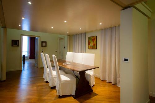a dining room with a table and white chairs at N 10, Luxury in Turin
