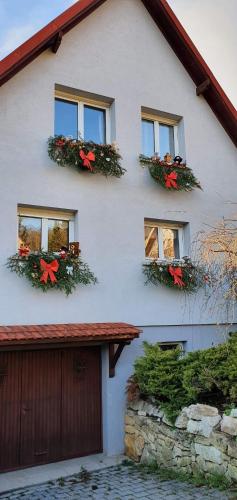 ein weißes Haus mit Weihnachtskränzen an den Fenstern in der Unterkunft Chambre des Acacias 