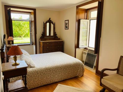 1 dormitorio con cama, tocador y espejo en Casa de Santa Bárbara - Cinfães, en Cinfães
