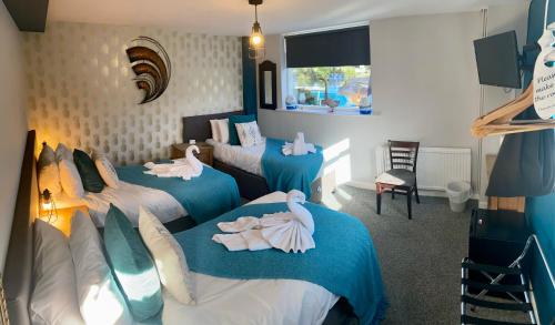Una habitación con tres camas con cisnes. en The Riverside inn en Saltford