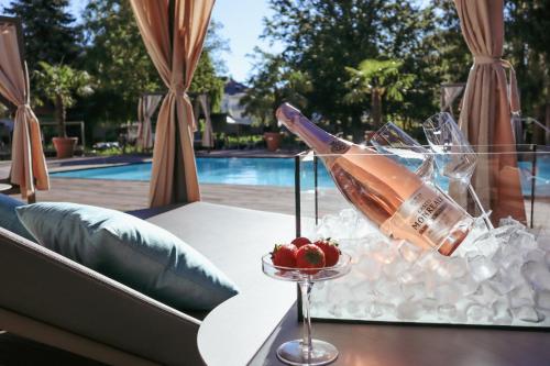 eine Flasche Champagner und eine Schale Obst auf dem Tisch in der Unterkunft Das Parkhotel in Bad Wörishofen