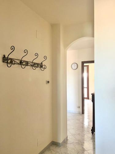 un corridoio con un muro con un orologio sul muro di La Maison il sole a Pisa