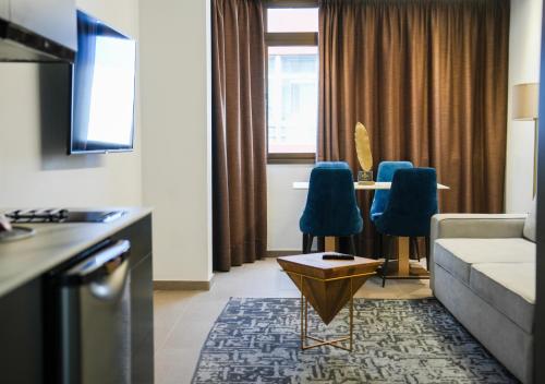 sala de estar con sofá y mesa con sillas en Poem Suites, Las Canteras, en Las Palmas de Gran Canaria