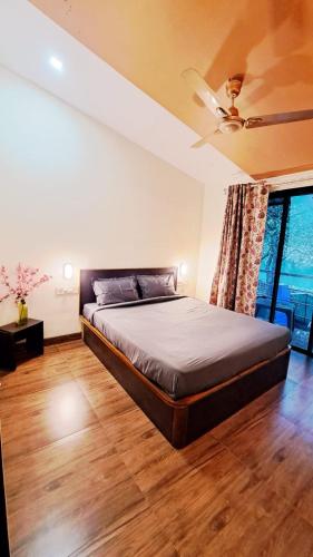 a bedroom with a bed and a ceiling fan at Neuaura Stays in Mahabaleshwar