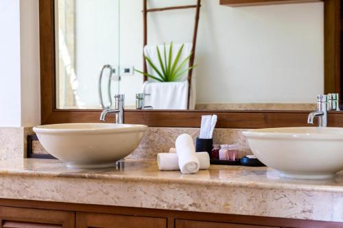 a bathroom counter with two sinks and a mirror at Villa Baan Saitara in Lamai