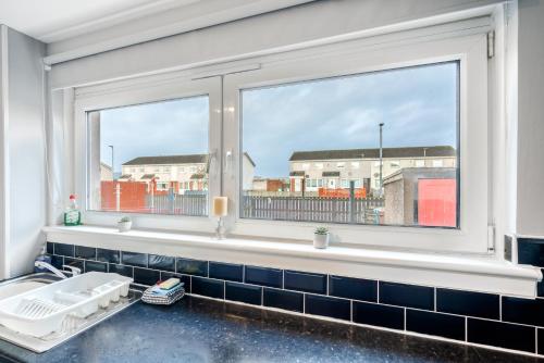 ein Bad mit einem Fenster und einem Waschbecken in der Unterkunft Balloch House -Spacious 3 bed house with on street parking in Kirk of Shotts