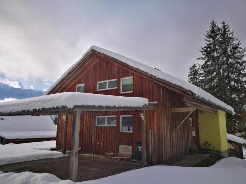 a barn with snow on the roof of it at Haus Branol in Hermagor
