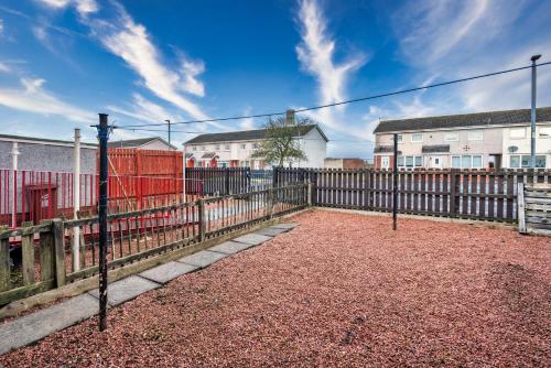 a fence in front of a building with houses at Balloch House -Spacious 3 bed house with on street parking in Kirk of Shotts