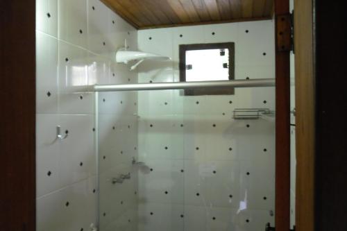La salle de bains est pourvue d'un mur blanc et d'une fenêtre. dans l'établissement Pousada Marumbe, à Macacos