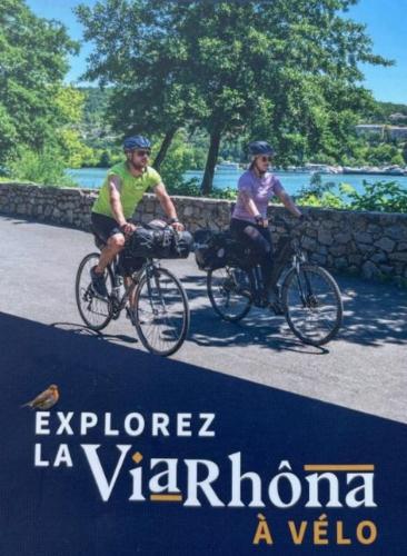 two people riding bikes in a sign that reads explore la yaronga ava at Kyriad Hotel Lyon Givors in Givors