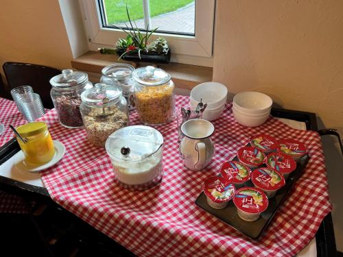 Ferienhof Spreewaldromantik في بورغ (سبريوالد): طاولة عليها مفرش طاولة أحمر منقوش عليه برطمانات طعام