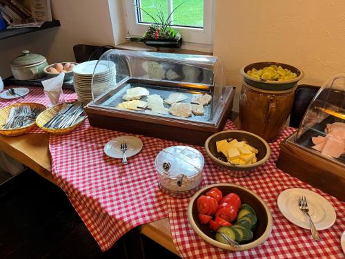 Ferienhof Spreewaldromantik في بورغ (سبريوالد): طاولة مع الطعام على قماش طاولة حمراء وبيضاء