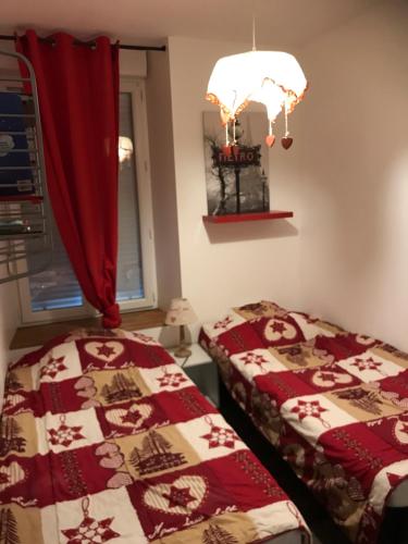 1 dormitorio con 2 camas y cortina roja en Résidence les Capucines, en Le Mont-Dore