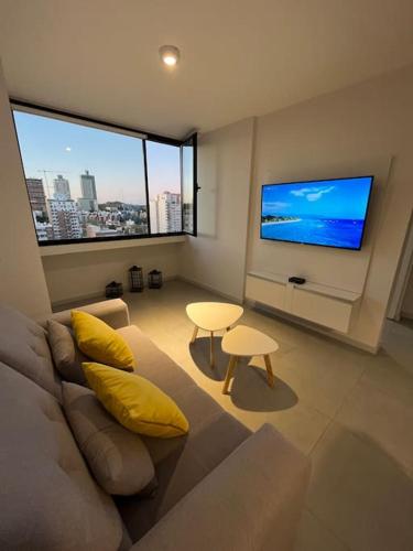 a living room with a couch and a flat screen tv at Hermoso departamento de un dormitorio en Neuquén in Neuquén