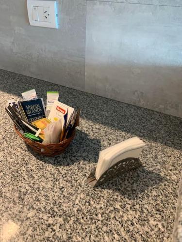 a basket of books sitting on a counter next to a clock at Hermoso departamento de un dormitorio en Neuquén in Neuquén