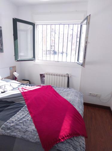 sypialnia z łóżkiem przykrytym czerwonym kocem w obiekcie Hostal El Caracol w mieście Valdemoro