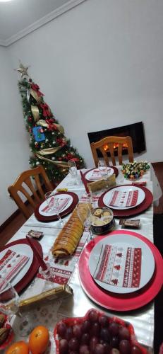 una mesa con platos de comida y un árbol de Navidad en Hostal El Caracol, en Valdemoro