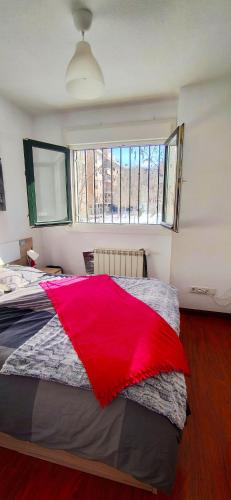 sypialnia z dużym łóżkiem, na którym znajduje się czerwony koc w obiekcie Hostal El Caracol w mieście Valdemoro