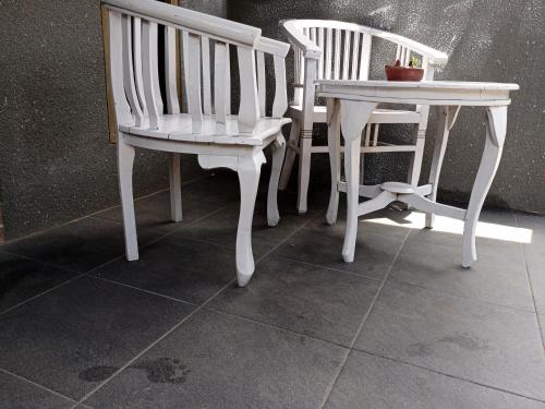 Oda Bungalows في غيلي تراوانغان: كرسيين أبيضين بجوار طاولة وطاولة عليها نبات