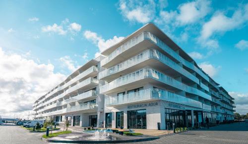 a large white building with glass windows at POLANKI AQUA Apartamenty PREMIUM - w cenie nielimitowany dostęp do strefy Aqua in Kołobrzeg