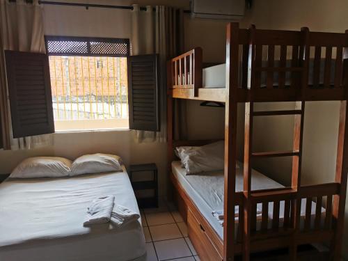 a bedroom with two bunk beds and a ladder at Sos Hostel in Camaçari
