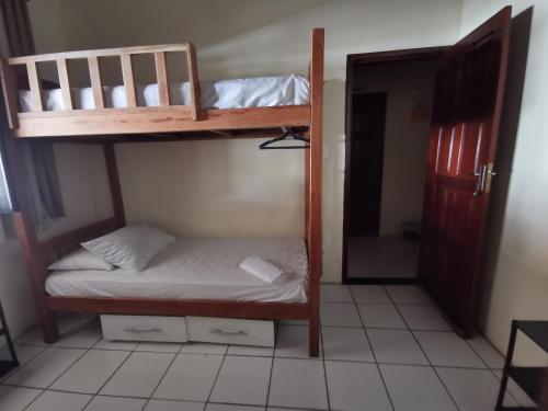 a bedroom with two bunk beds in a room at Sos Hostel in Camaçari