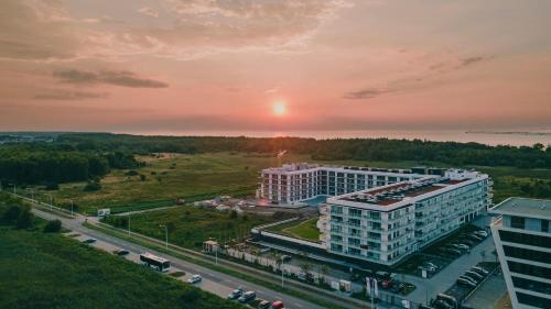 an aerial view of a building with the sunset in the background at POLANKI AQUA Apartamenty PREMIUM - w cenie nielimitowany dostęp do strefy Aqua in Kołobrzeg