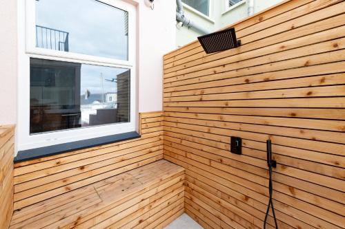 a wooden wall in a room with a window at MORLANOW-Private entrance, courtyard, sea views in Newquay
