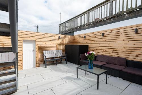 een patio met een bank en een tafel bij MORLANOW-Private entrance, courtyard, sea views in Newquay