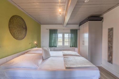 ein großes weißes Bett in einem Zimmer mit Fenster in der Unterkunft Reethus Koldenbüttel in Hollbüllhuus