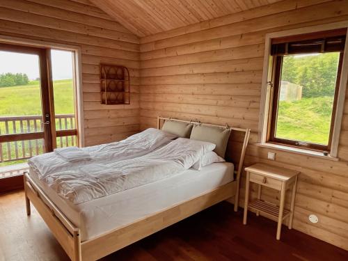 a bed in a wooden room with a window at Helgafell retreat center in Akureyri