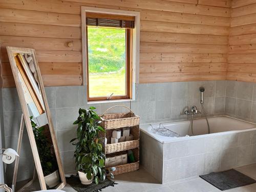 a bathroom with a bath tub and a window at Helgafell retreat center in Akureyri