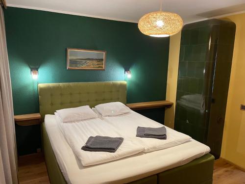 a bedroom with a bed with a green wall at "Indian Summer" Apartment in Viljandi