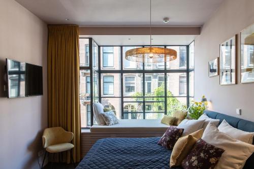 a bedroom with a bed and a large window at Luxurious Residence in Vondelpark/Museum District in Amsterdam