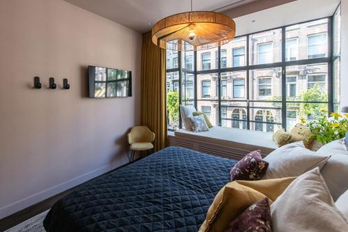 a bedroom with a blue bed and a large window at Luxurious Residence in Vondelpark/Museum District in Amsterdam