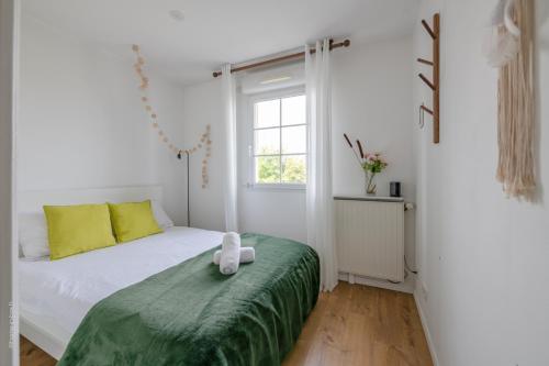 a bedroom with a bed with a green blanket and a window at Superb family duplex clos to Disneyland in Bussy-Saint-Georges