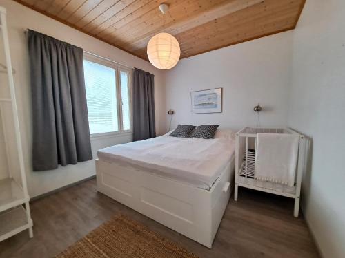 um quarto com uma cama branca e uma janela em Villa Tohonnokka em Kalajoki