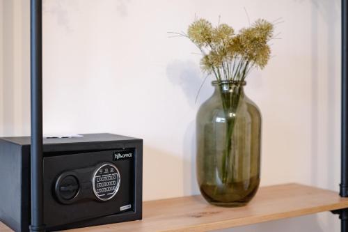 a vase with flowers in it next to a speaker at Alex & Rine - Pension Zum Alten Strom in Warnemünde
