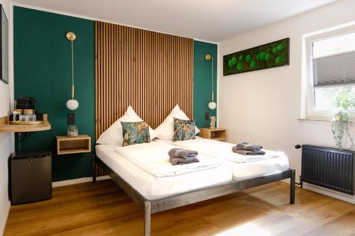 a bed in a room with a green wall at Alex & Rine - Pension Zum Alten Strom in Warnemünde